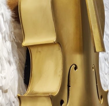 Detalle de instrumento musical dorado tipo violonchelo en escultura de JSUS ART DELUXE. Arte objeto clásico reinterpretado en formato lujo.